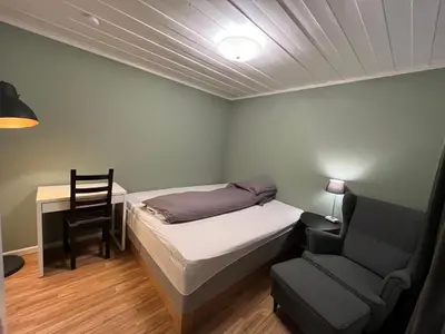 a bedroom with a bed and a chair and a desk at Koselig rom i rolige omgivelser in Rena