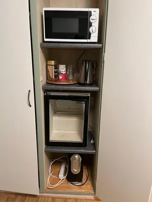 a microwave oven sitting on top of a refrigerator at Koselig rom i rolige omgivelser in Rena