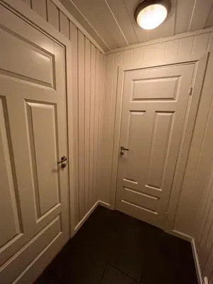 an empty room with a door and a light at Koselig rom i rolige omgivelser in Rena