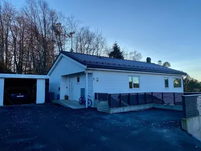 a white house with a garage and a driveway at Your Dream Studio in Bergen in Bergen