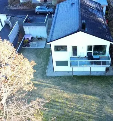 a white house with a black roof and a yard at Your Dream Studio in Bergen in Bergen