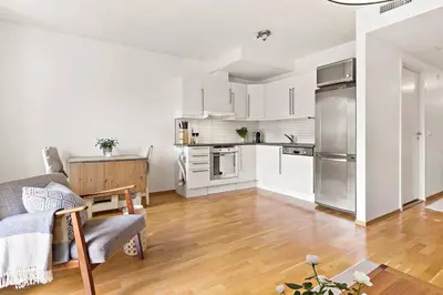 a living room with a couch and a kitchen at Flott leilighet på Nygårdshøyden in Bergen