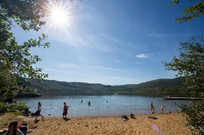 a group of people on the beach at a lake at Stay in the heart of Geilo, walk to everything in Geilo