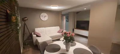 a living room with a white couch and a table with flowers at Cozy and warm just like at home, Free P, Big terrace in Langevåg