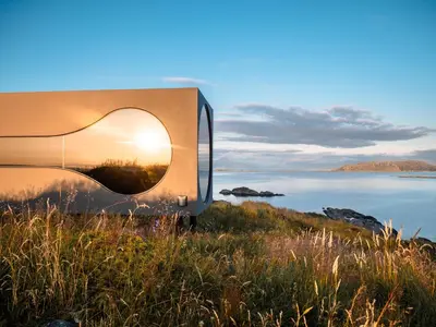 a building on a hill with a view of a body of water at Birdbox Reksta in Florø