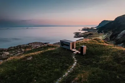 a television sitting on top of a hill next to the water at Birdbox Reksta in Florø