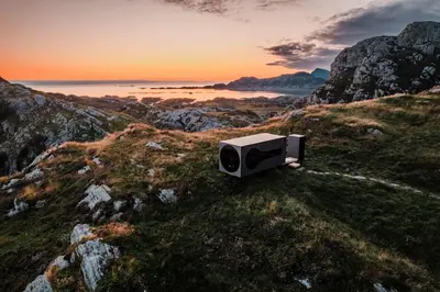 a television sitting on top of a hill with the sunset at Birdbox Reksta in Florø