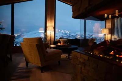 a living room with a fireplace and a large window at The View - Hodlekve in Sogndal