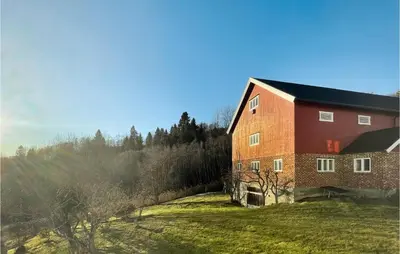 a large red brick building on a grass field at 4 Bedroom Cozy Home In Svorkmo in Brattli