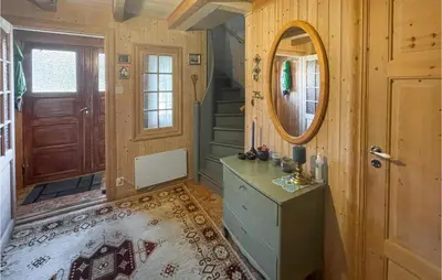 a room with a mirror and a dresser and a door at 4 Bedroom Cozy Home In Svorkmo in Brattli