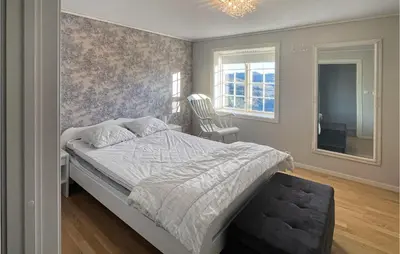 a bedroom with a bed and a chair in it at 4 Bedroom Cozy Home In Svorkmo in Brattli