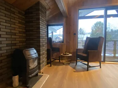 a living room with two chairs and a fireplace at Newly renovated apartment with a central location in Geilo