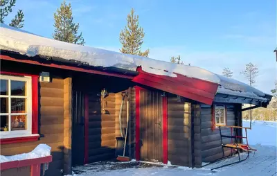 a log cabin with a red door in the snow at 5 Bedroom Pet Friendly Home In Jordet in Jordet