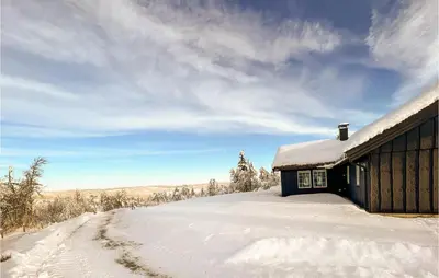 a snow covered building next to a snow covered road at 5 Bedroom Awesome Home In Røn in Ron