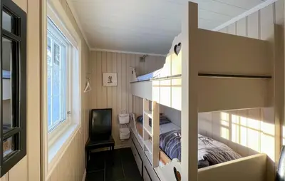 a small bedroom with a bunk bed and a window at 5 Bedroom Awesome Home In Røn in Ron