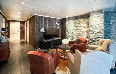 a living room with two chairs and a television at 5 Bedroom Awesome Home In Røn in Ron