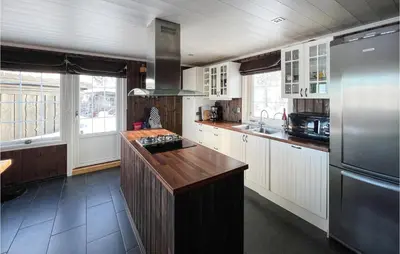 a kitchen with white cabinets and a stainless steel refrigerator at 5 Bedroom Awesome Home In Røn in Ron