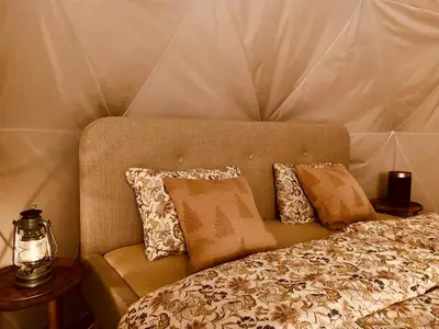 a bedroom with a bed with pillows on it at Dome Glamping with shared bathroom in Lillehammer