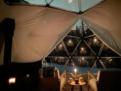 a room with a large window with a table and chairs at Dome Glamping with shared bathroom in Lillehammer