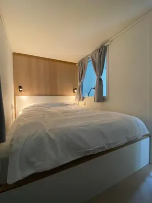 a bedroom with a large white bed with a window at Entire renovated apartment from 1780 with Kitchen, Bath, Bedroom, and Living Room in Skuteviken in Bergen