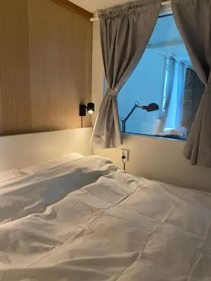 a white bed in a bedroom with a window at Entire renovated apartment from 1780 with Kitchen, Bath, Bedroom, and Living Room in Skuteviken in Bergen
