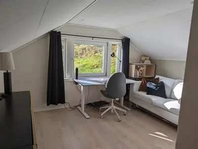 a room with a desk and a couch and a window at Nyoppusset hus med utsikt. in Steinkjer