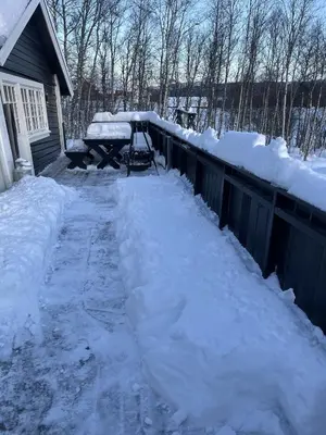 a yard covered in snow next to a fence at Stugu - Koselig hytte med sentral beliggenhet in Åker