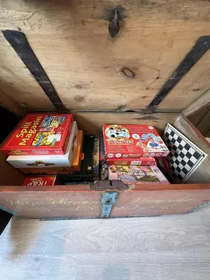 a pile of books sitting in a wooden box at Stugu - Koselig hytte med sentral beliggenhet in Åker