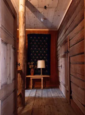 a room with wooden walls and a table with a lamp at Bergmannsgata 3 in Røros