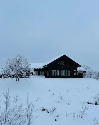 a house in a snow covered field with a building at Bjørnebuhytten, Geilo, 13 sengeplasser med privat Jacuzzi og el-bil-lading in Geilo
