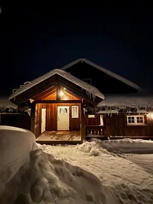 a cabin in the snow at night at Bjørnebuhytten, Geilo, 13 sengeplasser med privat Jacuzzi og el-bil-lading in Geilo