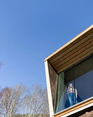 a woman is looking out the window of a house at Engeset Trehytter in Vereide