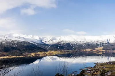 a view of a snowy mountain range with a lake at Engeset Trehytter in Vereide