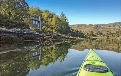 a kayak on a river in front of a house at Lovely Home In Stadlandet in Stadlandet
