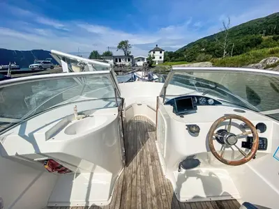 a white boat parked in a dock with a wheel at Holiday Home Sjøtun by Interhome in Hyllestad