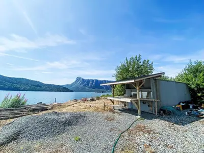 a shed sitting on the side of a lake at Holiday Home Sjøtun by Interhome in Hyllestad