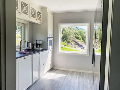a kitchen with white cabinets and a window at Holiday Home Sjøtun by Interhome in Hyllestad
