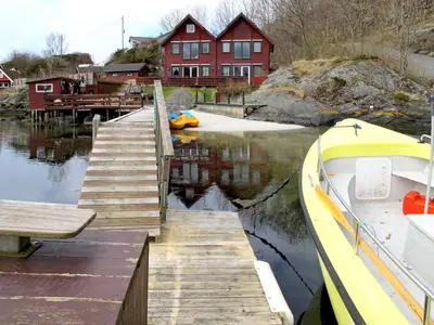 a boat docked next to a dock with a house at Holiday Home Kalavåg by Interhome in Kalavåg