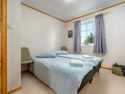 a bedroom with a bed with blue sheets and a window at Chalet Seievika by Interhome in Brekke