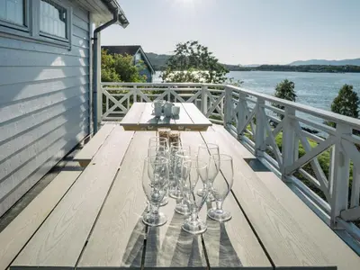 two wine glasses sitting on a table on a deck at Chalet Seievika by Interhome in Brekke