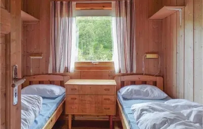 two twin beds in a room with a window at Bassebuupdalstøl in Tyinkrysset