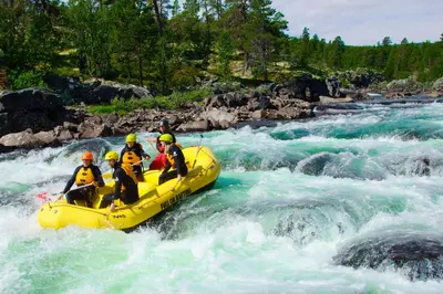 a group of people in a raft in a river at Active Adventure Base - Apartment & Lavvo, Dagali Fjellpark in Dagali