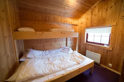a room with a bed in a wooden cabin at Active Adventure Base - Apartment & Lavvo, Dagali Fjellpark in Dagali