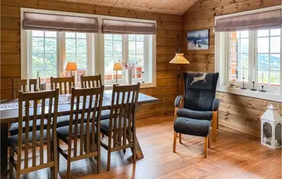 a dining room with a table and chairs and windows at 4 Bedroom Awesome Home In Nordfjordeid in Nordfjordeid