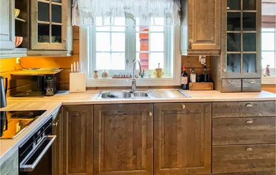 a kitchen with wooden cabinets and a sink at 4 Bedroom Awesome Home In Nordfjordeid in Nordfjordeid