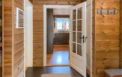 a door leading into a kitchen with wooden walls at 4 Bedroom Awesome Home In Nordfjordeid in Nordfjordeid