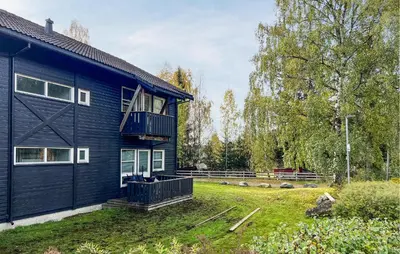 a black house with a balcony and a yard at 1 Bedroom Amazing Apartment In Øyer in Øyer