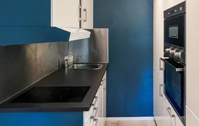 a kitchen with blue and white cabinets and a sink at 1 Bedroom Amazing Apartment In Øyer in Øyer