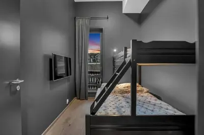 a bedroom with a bunk bed with a balcony at New Nice apartment Trysil alpine lodge with the lift right outside in Trysil