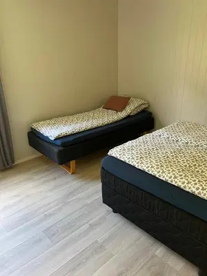 two twin beds in a room with wood floors at Tunold Gård - Olahuset in Oppstryn
